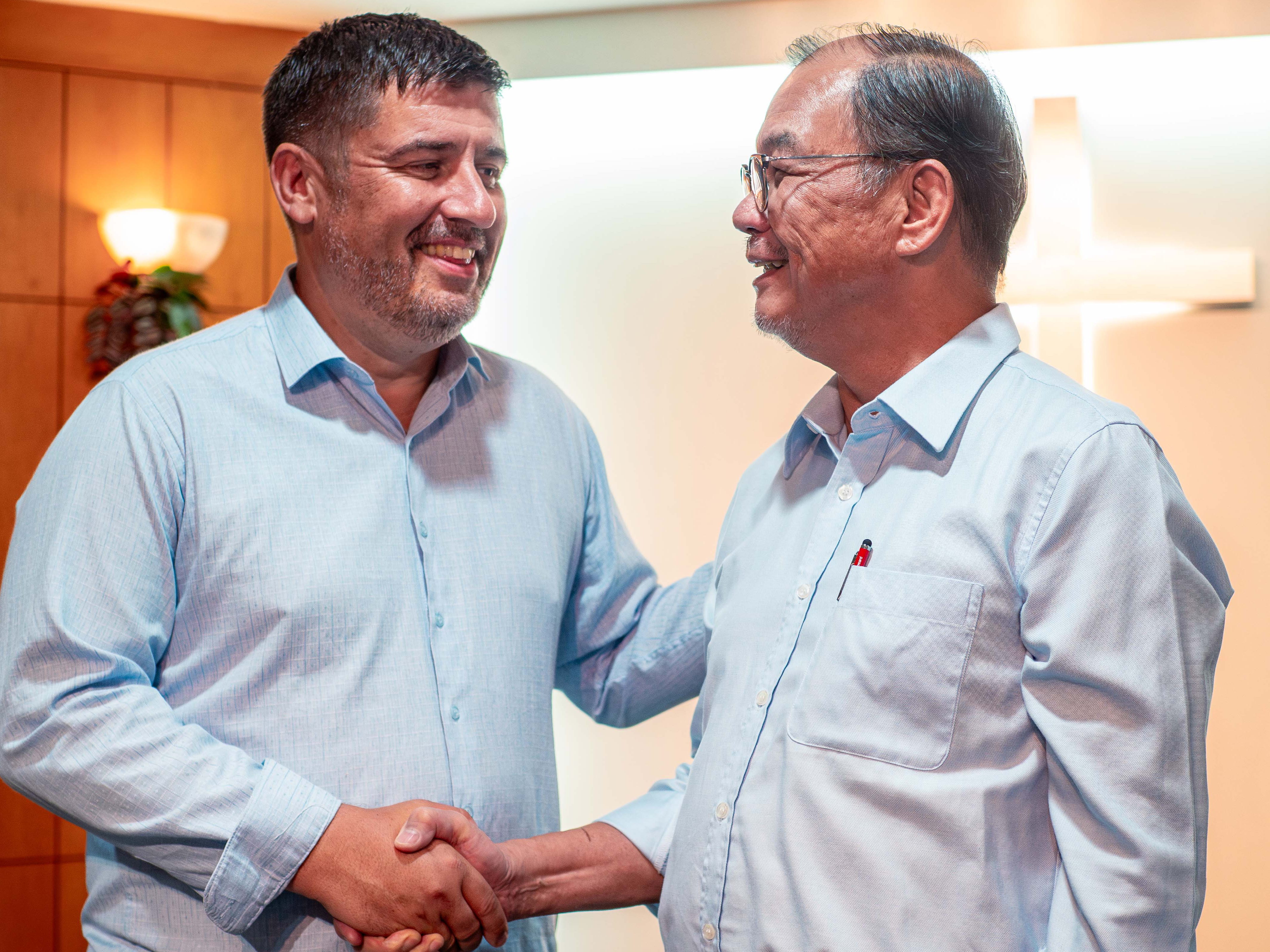 Image of Iain Pickett and Lawrence Tong shaking hands.